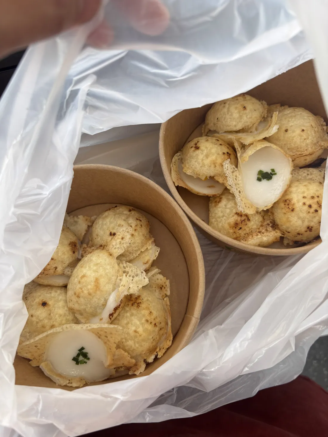 Khanom Krok — goldbraune Kokos-Küchlein in zwei Pappbechern