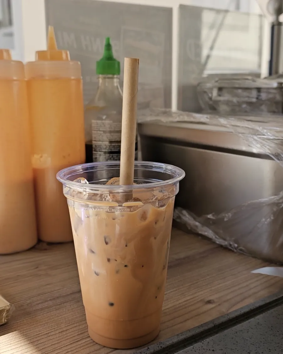 Original Thai Tea mit Eiswürfeln und Papierstrohhalm am Truck